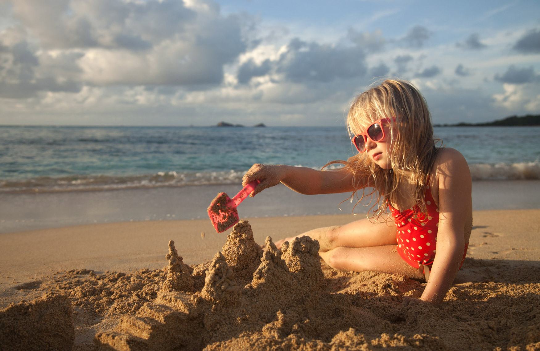 A-YOUNG-GIRL-BUILDING-A-SANDCASTLE-ON-THE-BEACH