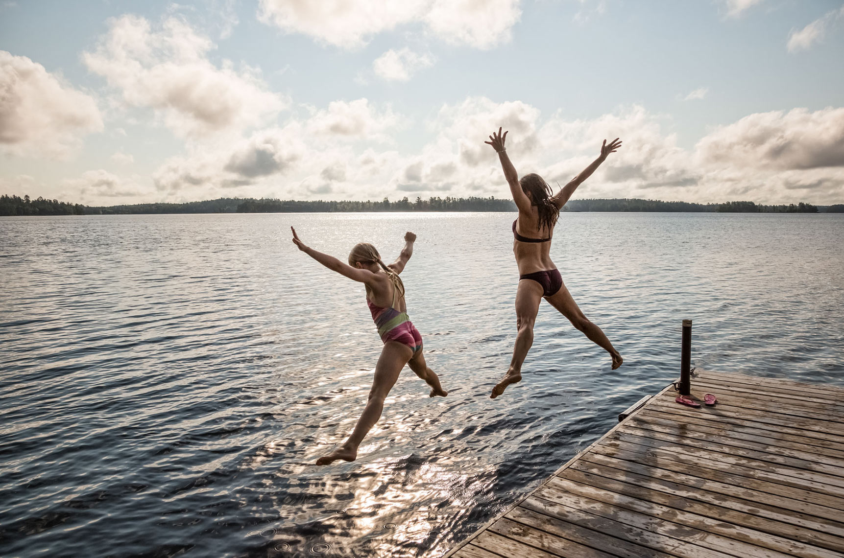 MOTHER-AND-A-DAUGHTER-JUMPING-OFF-A-DOCK