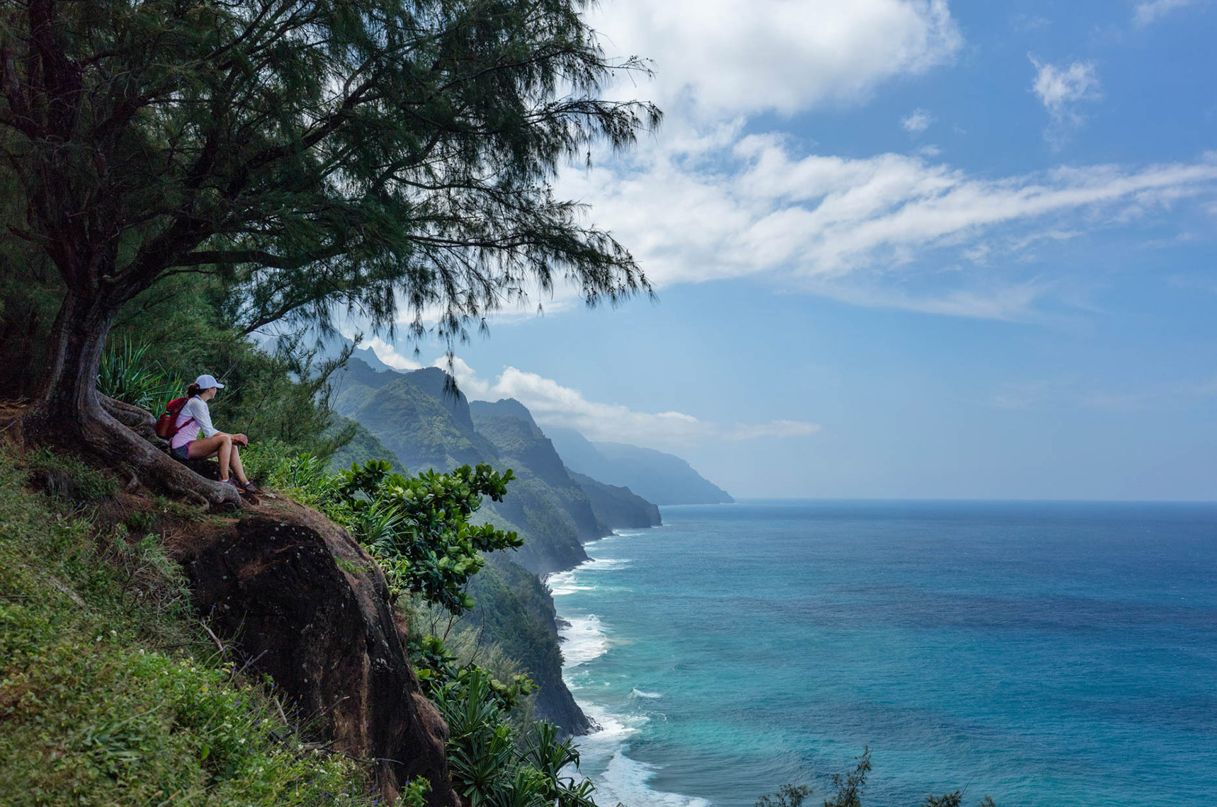 female-hiker-taking-in-Na-Pali-Coast-view_Kauai_Hawaii